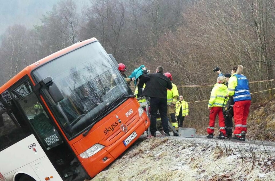 HJELP: Her får gutten hjelp til å komme seg ut av bussen. Det er glatt på veiene flere steder.