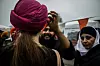 Bildet viser en jente som får på seg turban. En mann i turban hjelper til.