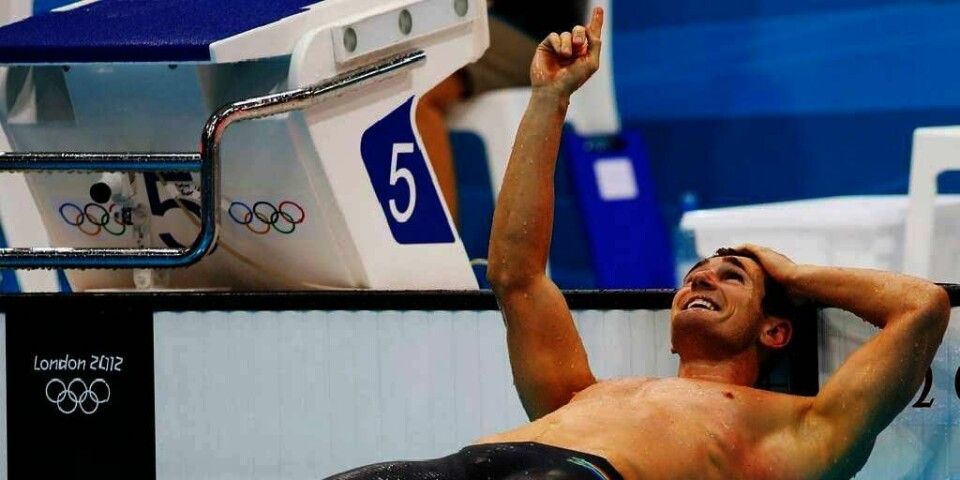 VINNER: Sørafrikanske Cameron van der Burgh satte ny rekord i konkurransen 100 meter bryst. Det skjedde under De olympiske leker (OL) i London i Storbritannia. Etter løpet pekte han opp mot himmelen for å hedre kameraten Alexander Dale Oen. Dale Oen døde plutselig i mai i fjor. Den norske svømmeren var god venn av van der Burgh. van der Burgh har tidligere sagt at han svømmer for Dale Oen.