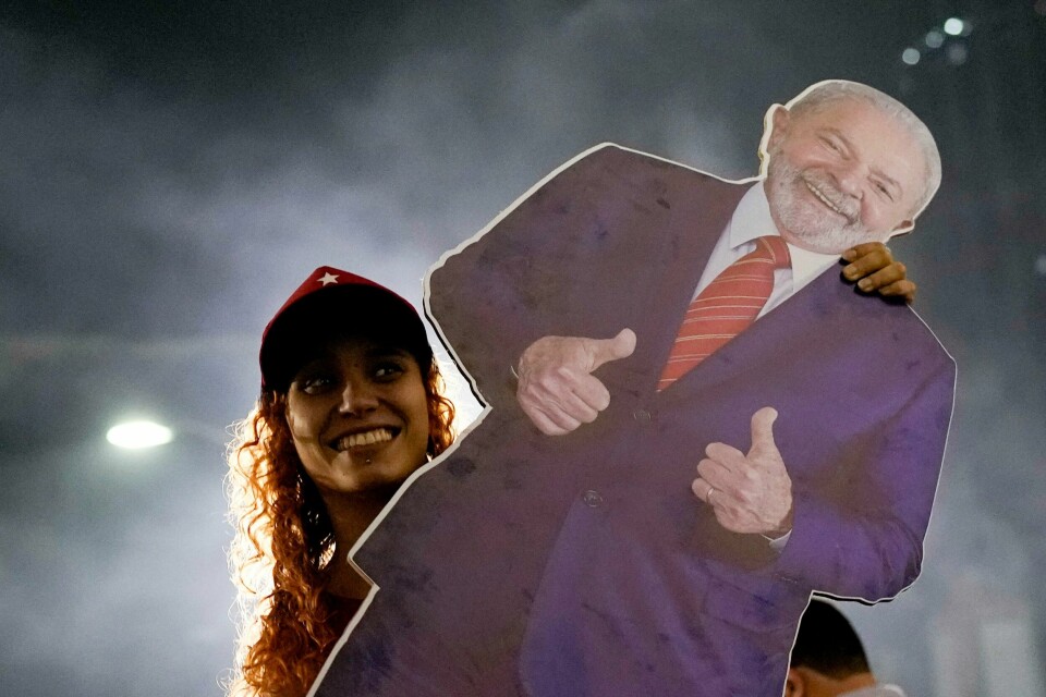 FLEST STEMMER: Lula da Silva fikk flest stemmer. Men det var for lite til å vinne valget i Brasil i første runde. Bildet viser en av Lulas støttespillere i Brasil med en plakat av ham. Foto: Silvia Izquierdo / AP / NTB