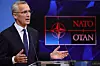 Bildet er av Jens Stoltenberg på en talerstol. Logoen til Nato er i bakgrunnen. Foto: Olivier Matthys / AP / NTB