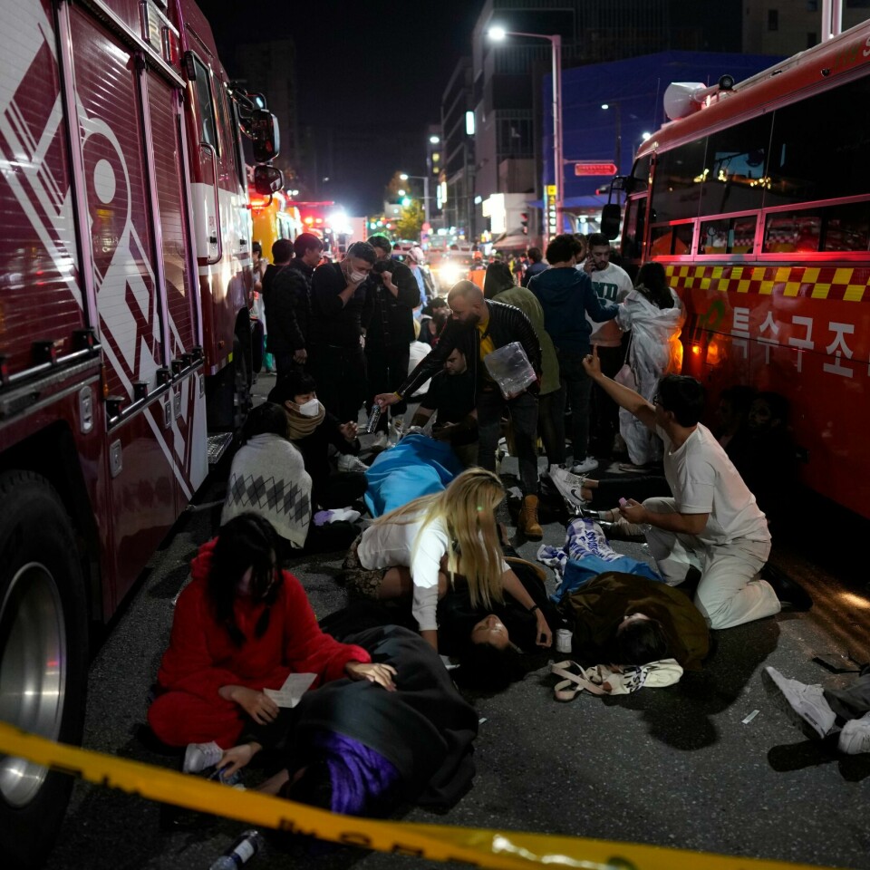 TRAGEDIE: Skadde mennesker får hjelp i en av gatene i Seoul. Mange mennesker er døde eller er skadd i trengselen under halloween-feiring byen. Foto: Skadde mennesker får hjelp i en av gatene i Seoul. Mange er Injuried people are helped at the street near the scene in Seoul, South Korea, early Sunday, Oct. 30, 2022. South Korean officials said around 50 people were in cardiac arrest and a number feared dead after being crushed by a large crowd pushing forward on a narrow street during Halloween festivities in the capital Seoul. (AP Photo/Lee Jin-man)