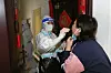 A medical worker takes swab sample from a residents during a door-to-door Covid-19 screening in Zhengzhou in central China's Henan province Tuesday, Nov. 1, 2022. Access to an industrial zone in the central Chinese city of Zhengzhou was suspended Wednesday after the city reported 64 coronavirus cases and workers who assemble Apple Inc. iPhones left their factory in the zone following outbreaks. (Chinatopix Via AP)