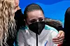 Bildet er av en trist Kamila Valijeva. Hun har på munnbind og en jakke fra den russiske olympiske komite. Hun får trøst av en kvinne som sitter ved siden av henne. Foto: David J. Phillip / AP / NTB