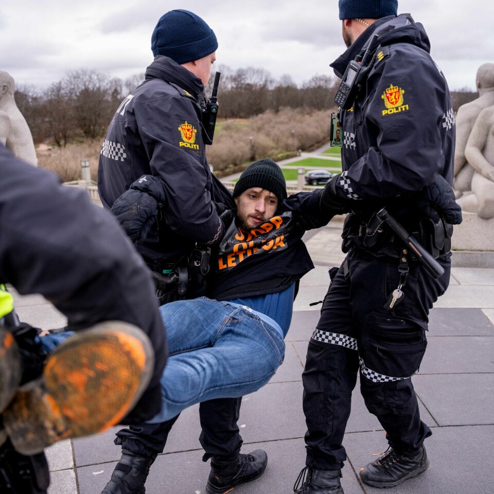 TILGRISET: Politiet bærer vekk Joachim Skahjem. Han var med på å grise til Monolitten i Vigelandsparken. Bildet viser politiet som bærer vekk Joachim Skahjem. Han og en annen aktivist griset til skulpturer i Vigelandsparken med maling i kampen for klimaet.