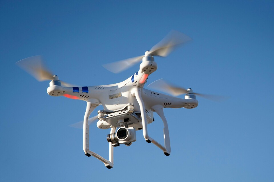 DØMT: En 34 år gammel russer er dømt for å ha fløyet drone i Norge. Det er ulovlig. Bildet er av en hvit drone i lufta. Det er blå himmel i bakgrunnen. Foto: Heiko Junge / NTB