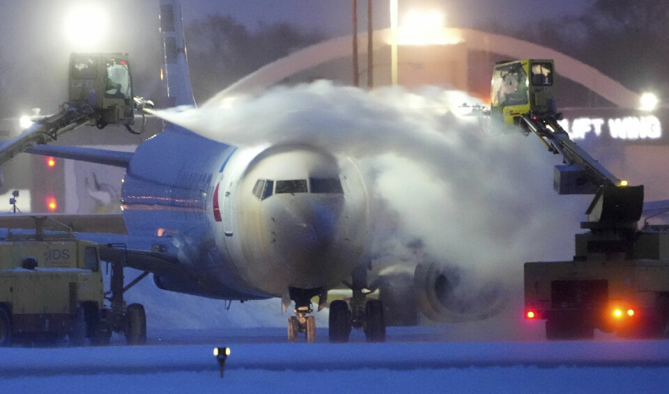 KALDT: Et amerikansk fly må fjerne is fra flyet. Her ved flyplassen i Minneapolis. Et fly blir aviset på Minneapolis-St. Paul International airport torsdag. Tusenvis av avganger er innstilt både torsdag og fredag, da mange amerikanere skulle reise hjem til jul. Foto: David Joles / Star Tribune via AP / NTB
