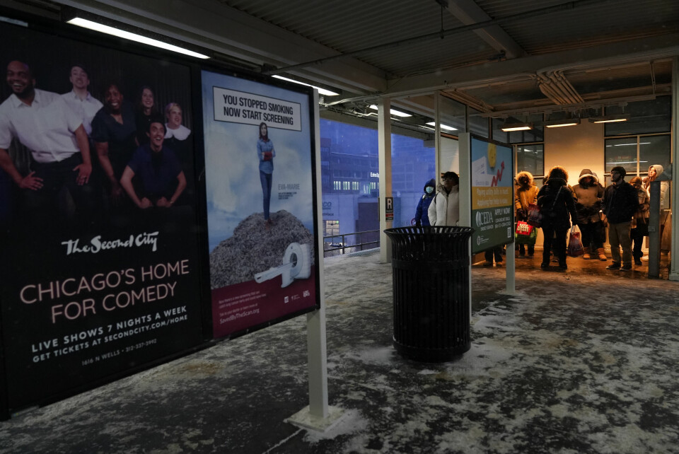 TOG: Folk venter på toget i Chicago. Her står de inne på en varmestasjon. Folk står i en varmestasjon mens de venter på toget i Chicago. Foto: Charles Rex Arbogast / AP / NTB