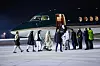 Bildet viser folk fra bevegelsen Taliban i Norge i 2022. De går mot et fly på Gardermoen. Foto: NTB