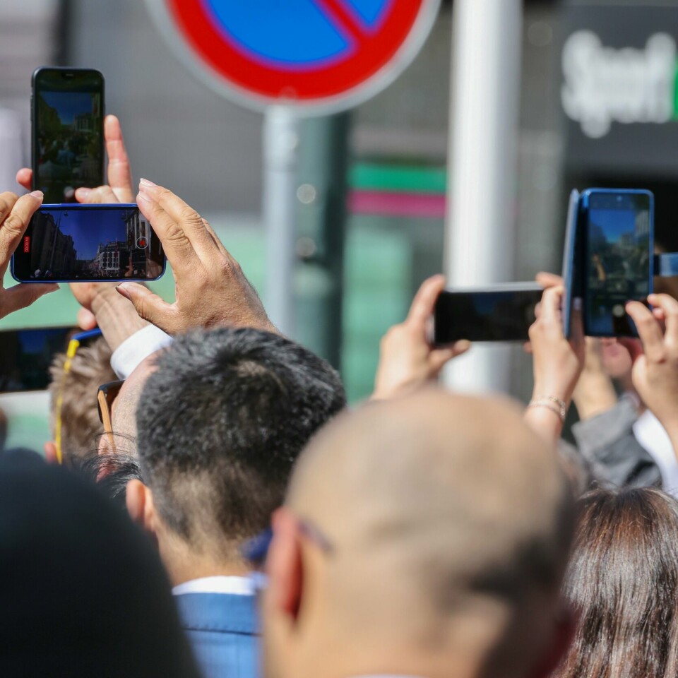 PASS PÅ: Mange skal ut og se på 17. mai-tog på nasjonaldagen. Pass på så ikke mobilen går i bakken, sier forsikringsselskap. Bildet viser folk i 17. mai-tog som tar bilder med mobiltelefon.