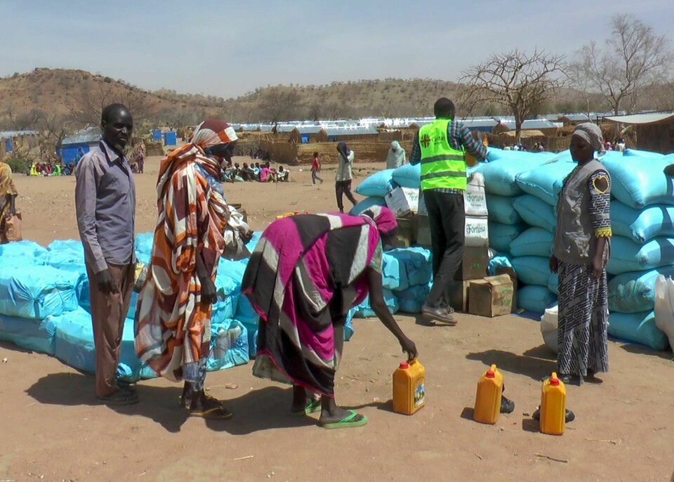 PÅ FLUKT: Konflikten i Sudan har skapt flere flyktninger, ifølge FN. Bildet viser sudanske flyktninger som får mat fra hjelpeorganisasjoner i Metche-leiren øst i nabolandet Tsjad. Foto: Jsarh Ngarndey Ulrish / AP / NTB.