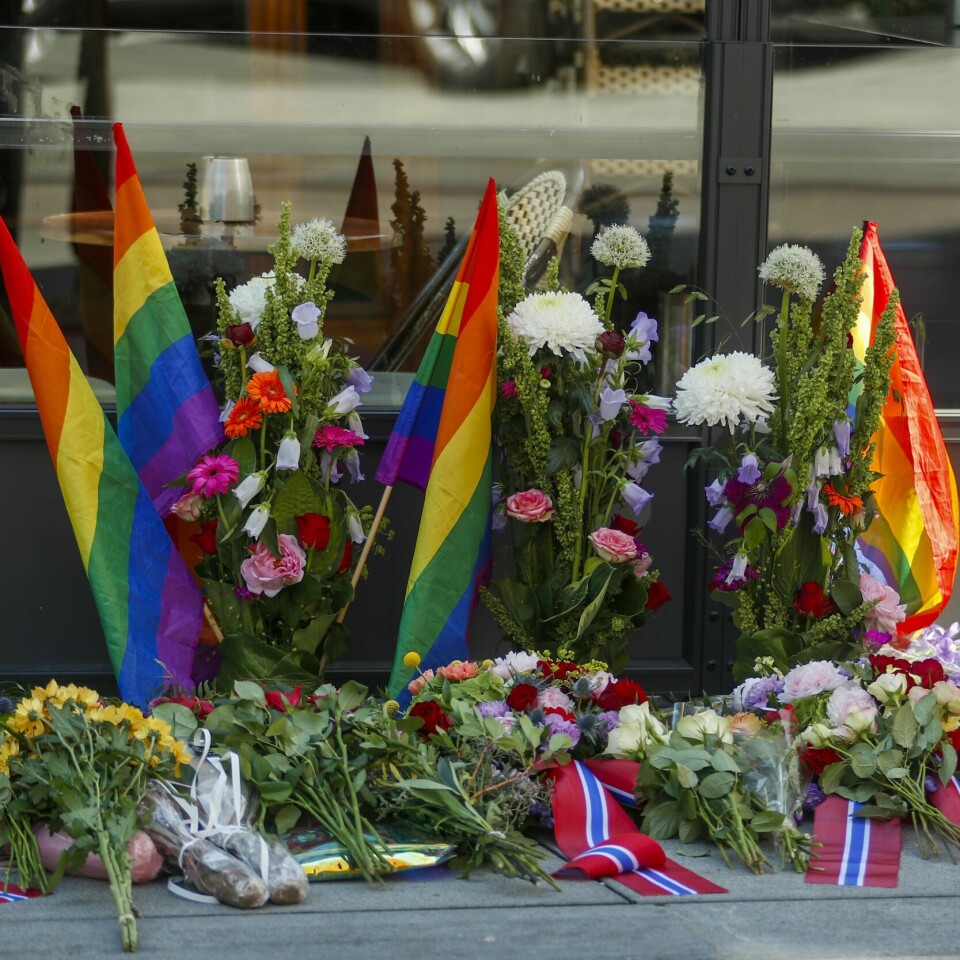 MARKERING: Folk markerte 25. juni i fjor. Støttegruppa 25. juni inviterer folk til å markere dagen i år også. Bildet viser blomster og prideflagg som er blitt lagt i området der terrorangrepet skjedde 25. juni 2022.