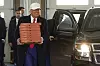 Donald Trump plukket med seg pizza på veien fra et valgmøte til et besøk på en brannstasjon i Iowa søndag. Foto: Andrew Harnik / AP / NTB