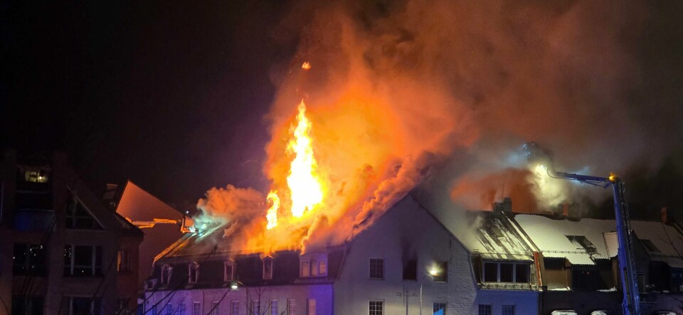 BRANN: Det brenner kraftig i en bygning i Fredrikstad sentrum. Bildet viser bygningen som brenner i Fredrikstad. Høye flammer slynger seg opp av taket.