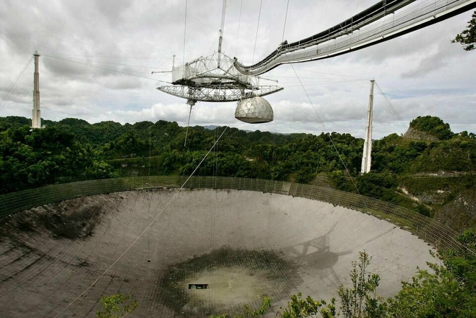 RØKET: Flere kabler som holder på plass utstyr over teleskopet, har røket. Nå skal Arecibo-teleskopet rives.