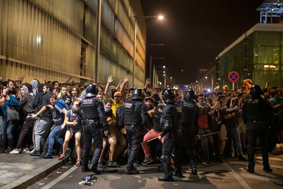 PROTESTER: Politiet forsøkte å holde folk tilbake under en demonstrasjon ved flyplassen i Barcelona. Folk ble rasende da tidligere katalanske ledere ble dømt til fengsel.