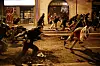 Bildet viser demonstranter som løper bortover en gate. Det er ventet enda større demonstrasjoner i Barcelona fredag kveld.