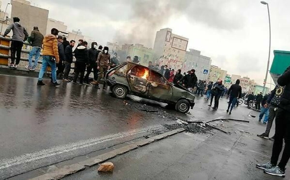 DEMONSTRERTE: Folk samlet seg rundt en brennende bil under protestene i Iran i november. Folk demonstrerte mot dyrere bensin. Bildet er fra hovedstaden Teheran.