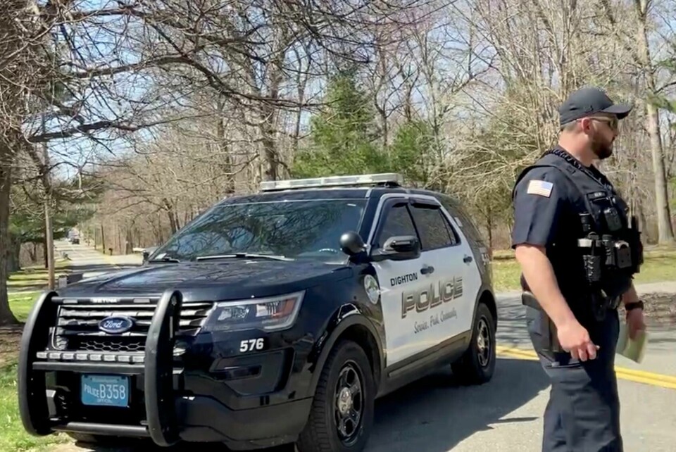 PÅGREP: FBI pågrep 21 år gamle Jack Teixeira. De tror han har lekket hemmelige dokumenter. Her passer politiet på. Bildet viser en amerikansk politimann og politibil.