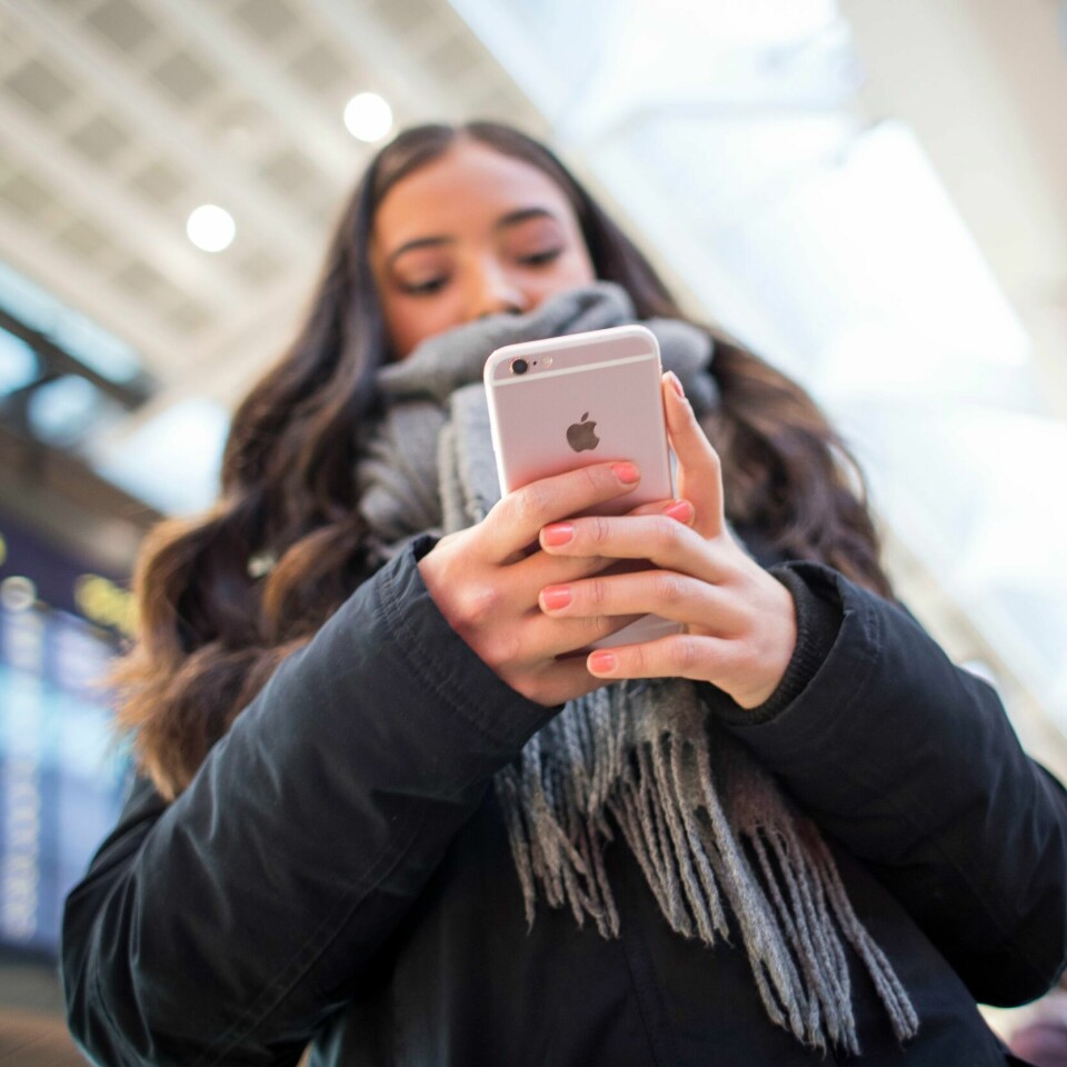 TEKNOLOGI: Hvor lenges synes du din mobiltelefon bør vare? Bildet viser ei jente med en mobiltelefon i hånden.