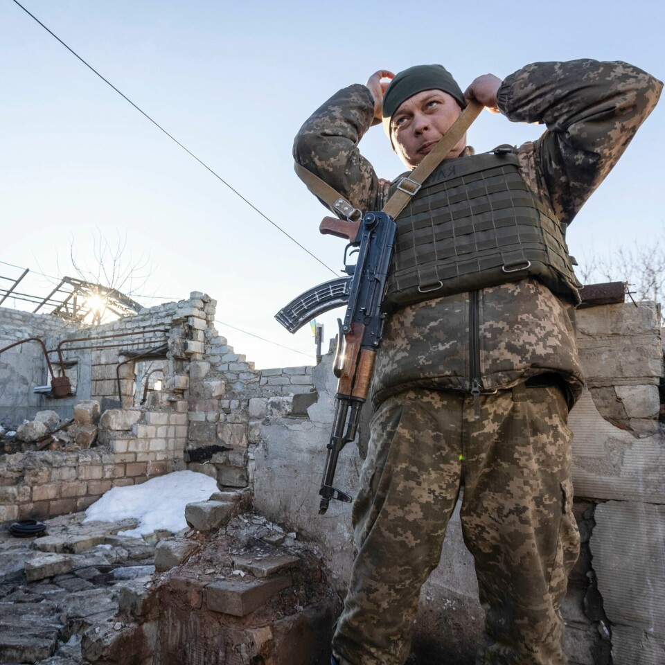 GRENSEN: En ukrainsk soldat står blant ruiner, i nærheten av grensen til området som er kontrollert av russerne. En ukrainsk soldat justerer geværet sitt i Donetsk-regionen ved et hus som ligger i ruiner som følge av krigen. Foto: Andrij Dubtsjak / AP / NTB