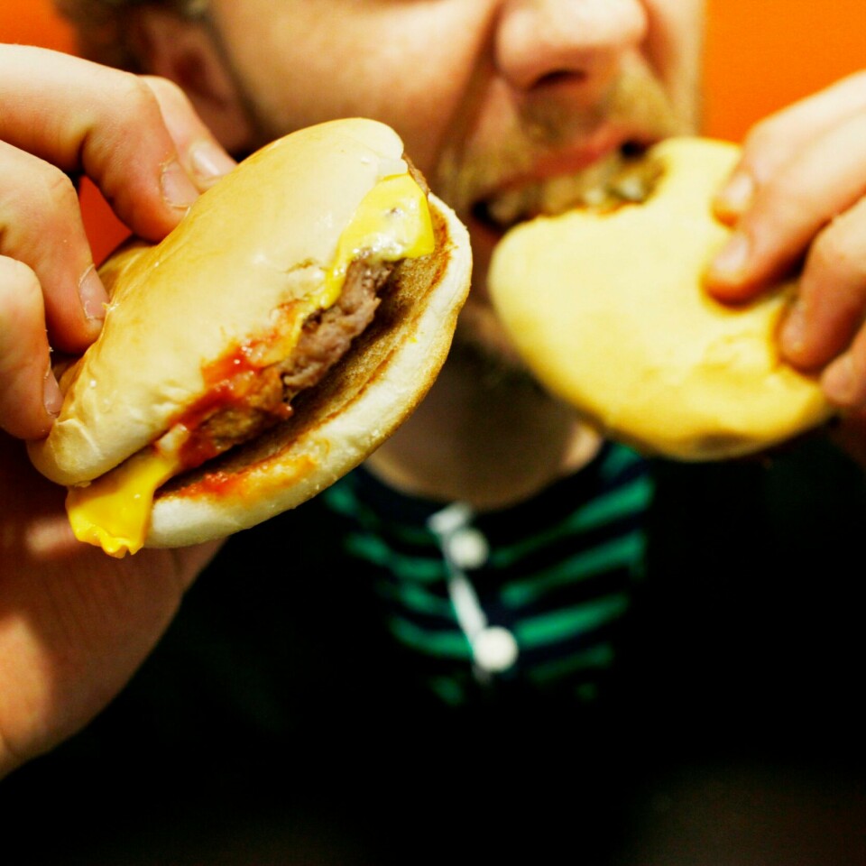 MINDRE: Vi bør spise mindre kjøtt, ifølge nye råd om kosthold. Bildet viser en mann som spiser hamburger.