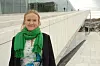 Bildet er av Caroline Solem. Hun står foran operaen i Oslo. Hun har lys bluse, mørk blazer og grønt skjerf. Foto: Dysleksi Norge