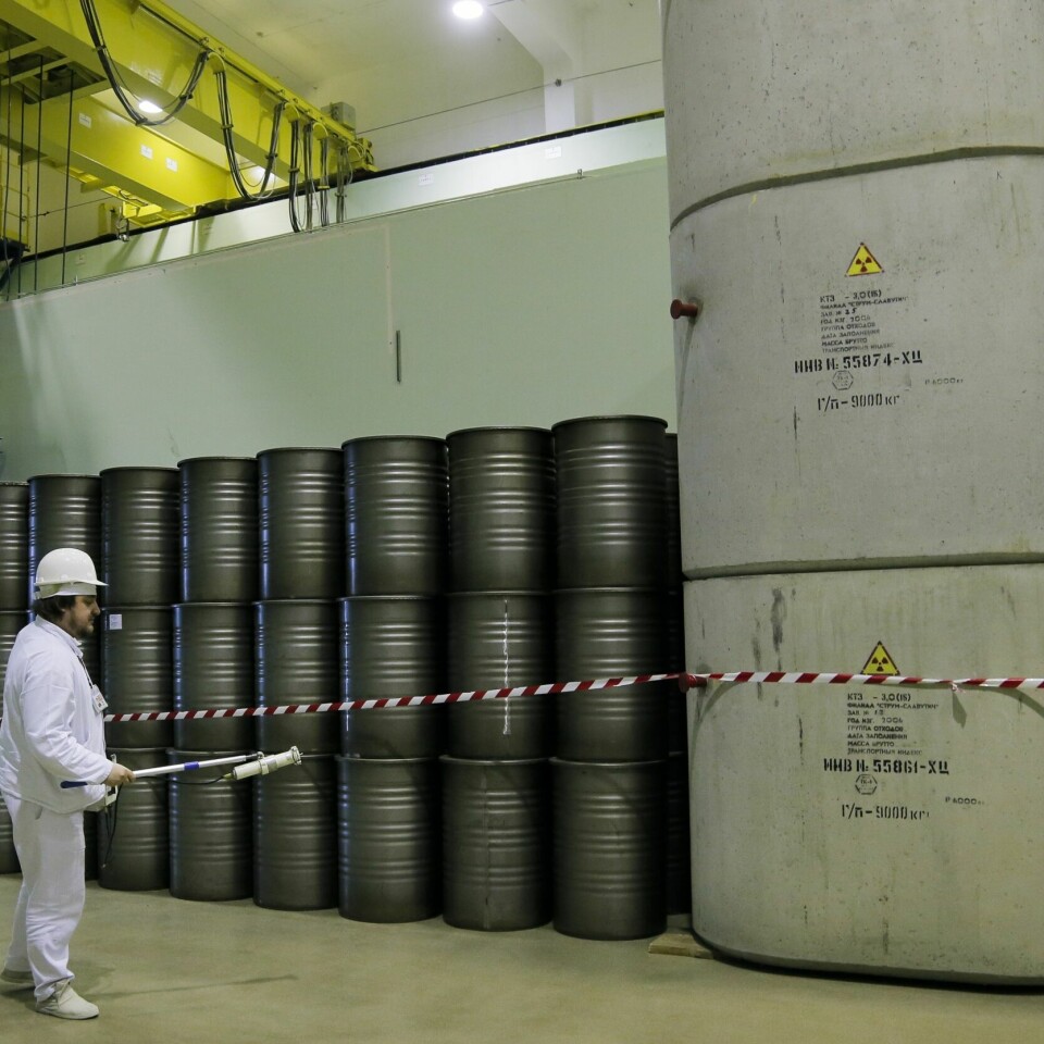 KRAFTVERK: Et gammelt bilde fra 2016 av en mann som målet radioaktivitet i Tsjernobyl. Arkivfoto fra mars 2016 som viser en arbeider sjekke radioaktivt nivå i beholdere med atomavfall i Tsjernobyl. Arkivfoto: Efrem Lukatsky / AP / NTB