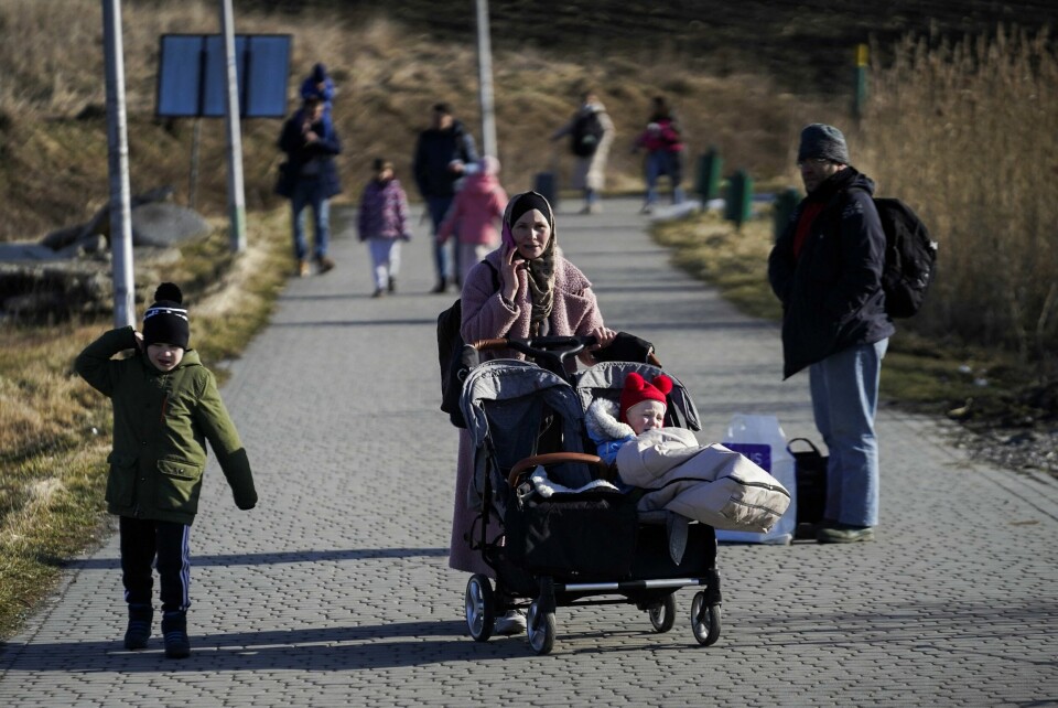 DRAR: Flere familier og andre folk drar over grensa til Polen. Årsaken er at Russland angriper Ukraina. Bildet viser en familie og andre som drar fra Ukraina og over grensa til Polen. Det skjer etter russiske angrep. REUTERS/Bryan Woolston