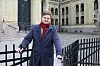 Bildet er av politikeren Tobias Drevland Lund. Han står ved porten til Stortinget. Han har på seg rødt skjerf og gråblå frakk.