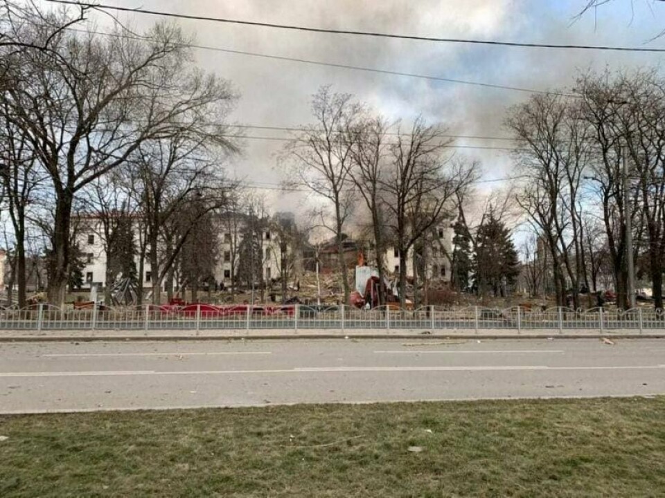 ANGREP: Russland angrep et teater med bombe, sier myndighetene i byen Mariupol. Russland skylder på Ukraina. Foto: Donetsk Regional Civil-Military Administration / Handout via REUTERS Bildet viser det som skal være et bombet teater i Mariupol i Ukraina. Røyk siver opp fra bygningen.