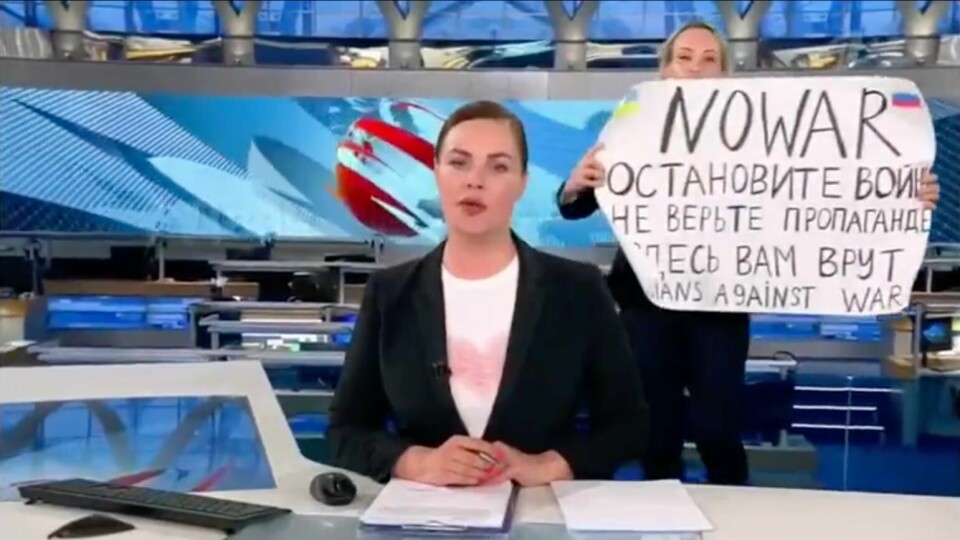 PROTEST: Marina Ovsjanniko holdt opp en plakat med budskap mot krigen. Det skjedde under en sending med nyheter på russisk TV mandag. Bildet viser Marina Ovsjanniko som holder opp en plakat med budskap mot krigen. Det skjedde under en sending med nyheter på russisk TV mandag.