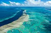 Bildet er av deler av Great Barrier Reef i Australa. Det er store områder med intens blå og grønne koraller. Men det er også områder som er helt grå. Foto: Jumbo Aerial Photography / AP / NTB