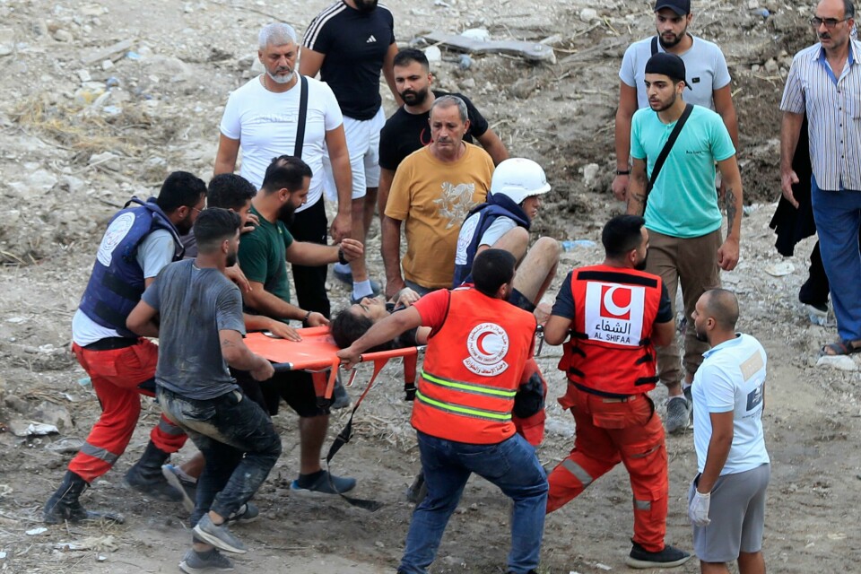 LIBANON: Redningsarbeidere frakter en såret mann etter et israelsk luftangrep øst for byen Saida søndag. Redningsarbeidere frakter en såret mann etter et israelsk luftangrep øst for byen Saida søndag. Foto: Mohammed Zaatari / AP / NTB