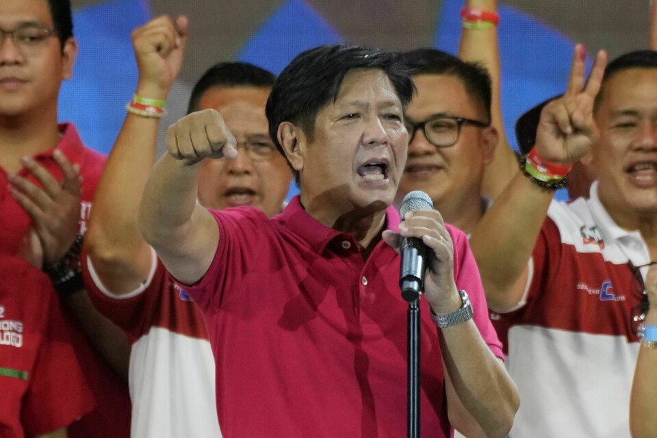 SEIER: Ferdinand «Bongbong» Marcos jr. sier han vant valget, og at han skal bli ny president på Filippinene. Bildet er av Ferdinand «Bongbong» Marcos jr. Han og tilhengerne hans er kledd i rødt. Han snakker i en mikrofon fra en scene. Foto: Aaron Favila / AP / NTB
