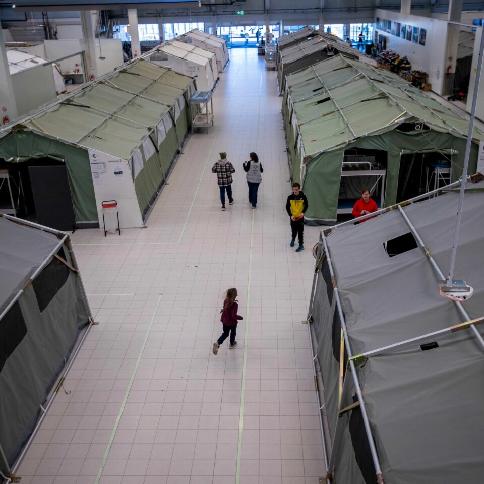 UENIGE: Den ukrainske foreningen i Norge vil unngå at det jobber russere på mottak der det kan komme folk på flukt fra krigen i Ukraina. Men UDI sier nei til å lage en sånn regel. Bildet er fra en stor hall, der det står mange store telt. Det er fra Nasjonalt mottakssenter i Råde. Det er folk som går rundt mellom teltene. Illustrasjonsfoto: Javad Parsa / NTB