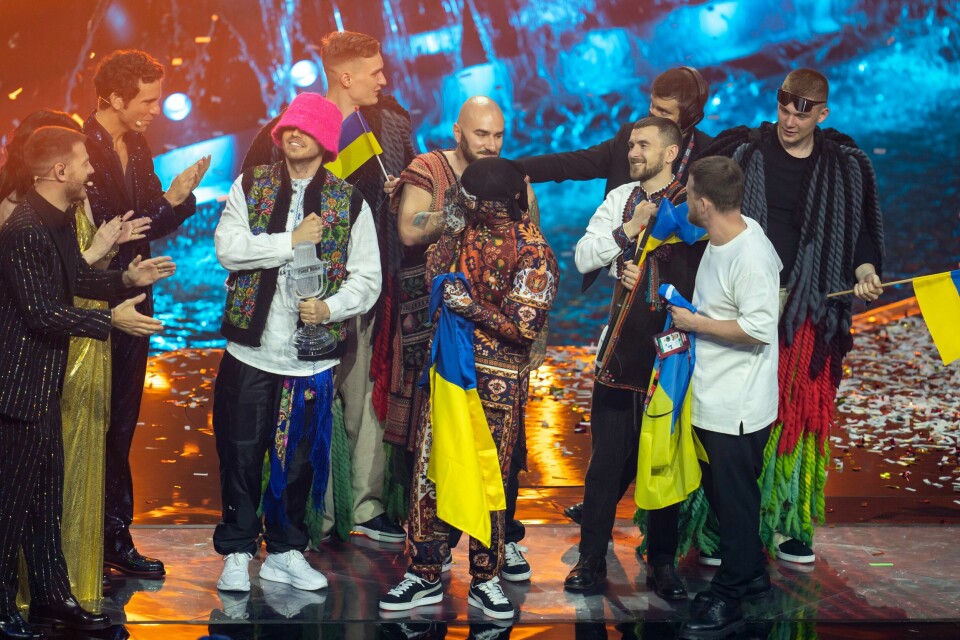 VANT: Ukraina og Kalush Orchestra vant finalen i Eurovision Song Contest i år. Men det blir ingen finale i landet neste år. Bildet er bandet Kalush Orchestra som står på scenen og tar imot trofeet etter at de vant finalen i Eurovision Song Contest i Pala Olimpico i Torino i mai. De har med seg ukrainske flagg. Foto: Heiko Junge / NTB