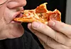 Bildet viser en person som spiser ferdigpizza. Foto: Terje Bendiksby / NTB