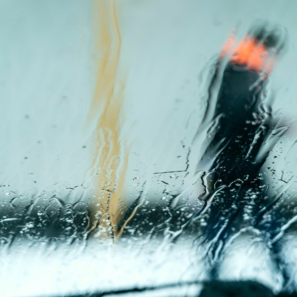 MYE REGN: Nord-Norge opplever uvær. Det blir mye regn og vind. Illustrasjons-foto. Bildet viser regn på ei rute og en person som går utenfor. Foto: Gorm Kallestad / NTB