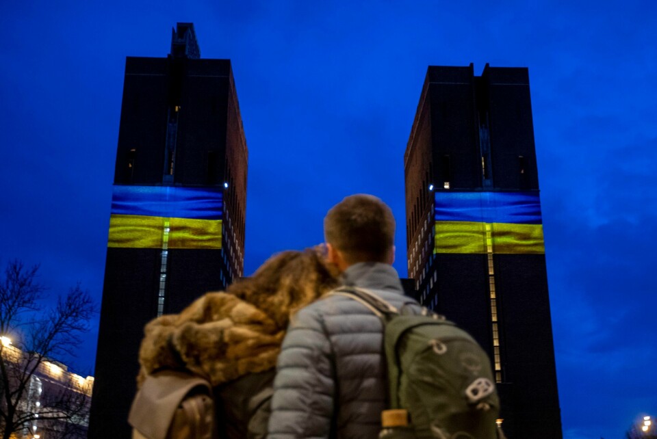 KRIG: Ukraina er i krig. Fredag er det ett år siden Russland invaderte landet. I 2014 tok de Krim-halvøya. Norge markerer årsdagen på flere måter. Bildet viser noen som ser på ukrainske flagg på en bygning.