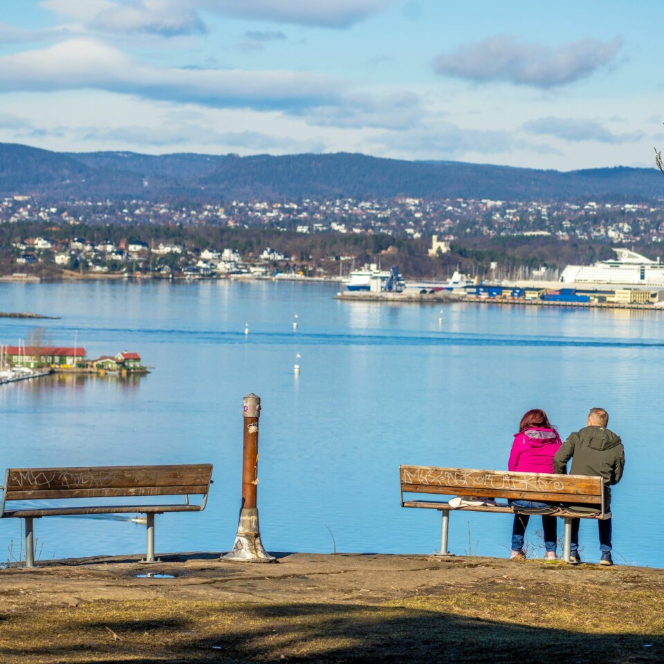 FERIE: De fleste holder skal feire påske innenfor Norges grenser, ifølge ny undersøkelse. Dette bildet er fra to år siden. To personer nyter utsikten ved Ekeberg i Oslo. Det var mange som var ute i den varme påskesola i Oslo, men de fleste holdt tilsynelatende god avstand. Her utsikten ved Ekeberg.Foto: Ole Berg-Rusten / NTB