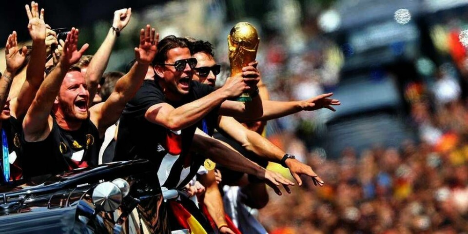 JUBEL:  Det tyske fotball-landslaget kjørte i en åpen buss til Brandeborger Tor i Berlin tirsdag. Der ble de mottatt av hundretusener av jublende mennesker.