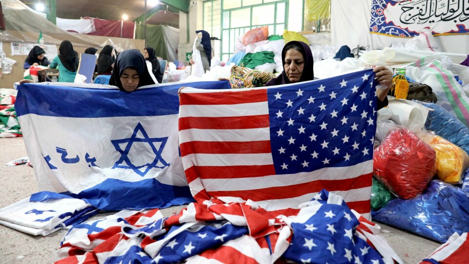 FLAGG: En fabrikk i Iran lager flagg. Folk brenner flaggene i demonstrasjoner.