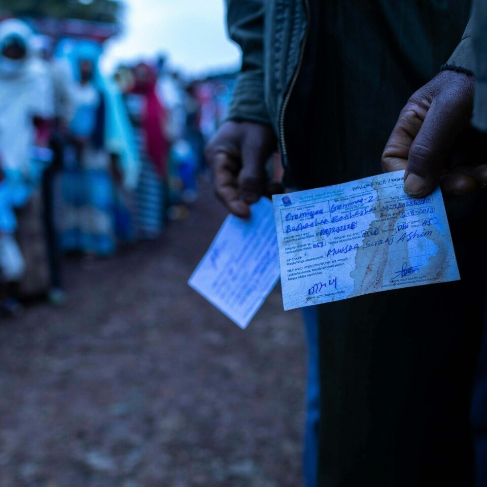 Folk står i kø for å avgi sin stemme. De skal velge over hvem som skal styre Etiopia. Folket kan velge mellom flere partier. Men det er avdekket falske valglokaler. Mennesker står i kø ved valglokaler i Etiopia. To menn står med valgsedler bortenfor køen.