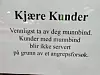 Bildet er av et skilt i et vindu. Det er en oppfordring om at kunder skal ta av seg munnbind. Kunder med munnbind blir ikke servert som følge av et ransforsøk.