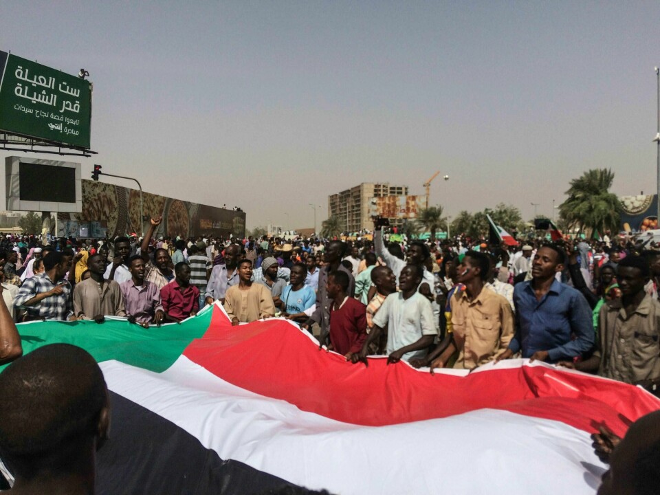 PROTESTERER: Demonstranter holder det sudanske flagget. Bildet er tatt etter at presidenten sluttet.