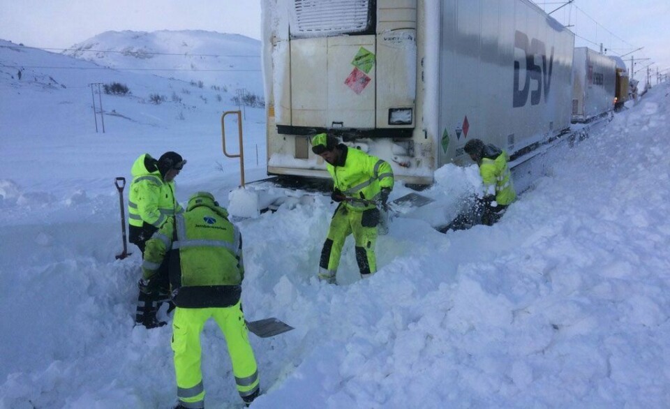 FAST: Et godstog kjørte seg fast i snøen. Folk fra selskapet Bane NOR måtte grave det fram med spader.