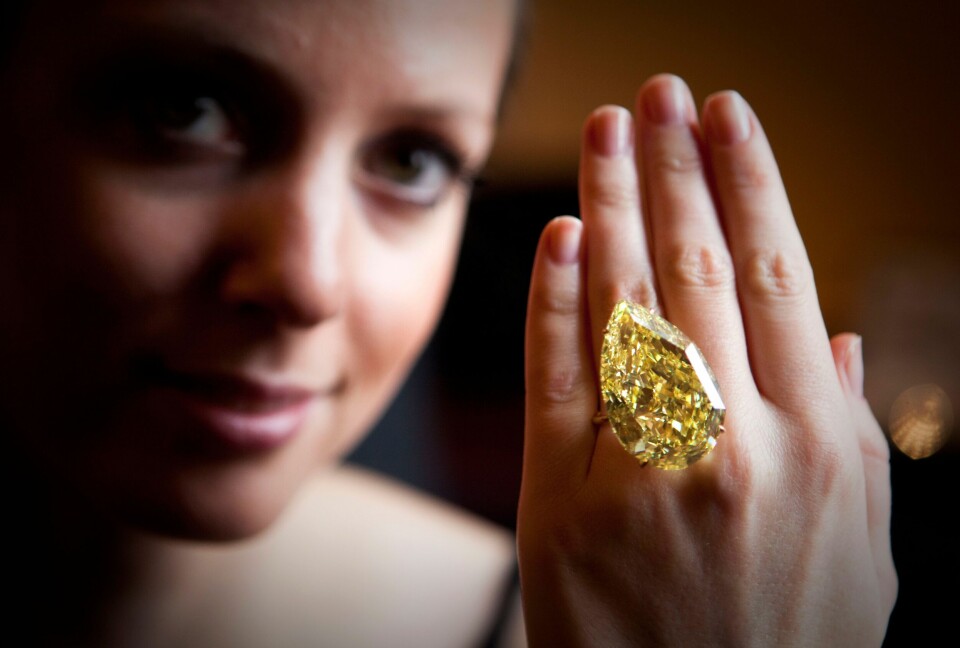 DIAMANT: Denne diamanten kjem frå Sør-Afrika. Den blei seld for om lag 85 millionar kroner på ein auksjon i 2011. Bilder viser ei dame som har på seg en stor, gul diamant på fingeren.