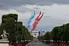 Bildet viser feiringen av nasjonaldagen i Paris. Gatene er pyntet med flagg og jetfly flyr over himmelen med de franske fargene.