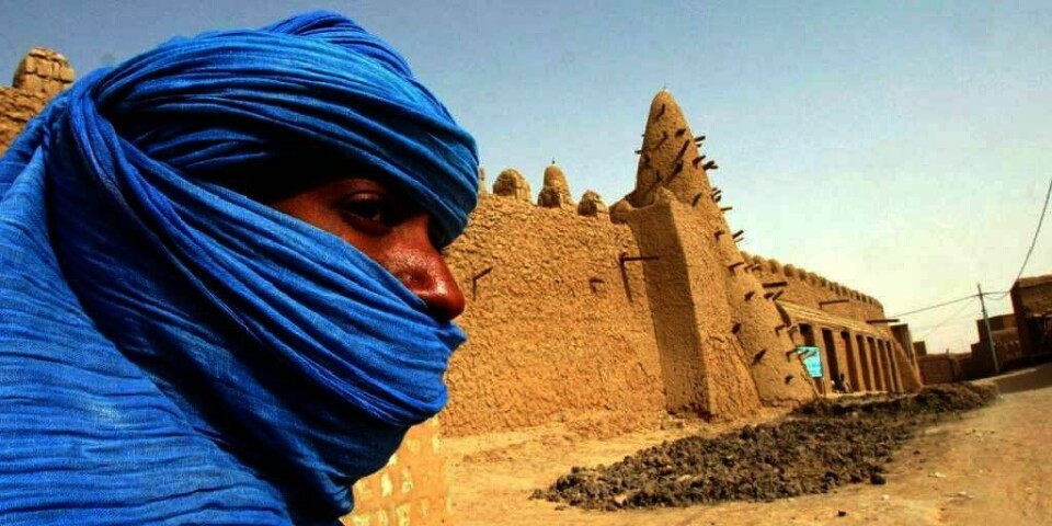 En person fra «Det blå folket» står foran en av moskeene i Timbuktu. Den er laget i leire, og er 700 år gammel. Nå frykter mange at kultur-arven i denne spesielle byen vil bli ødelagt av ekstreme islamister.